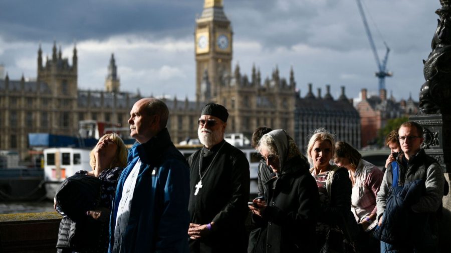 Members of the public stand in the queue as they wait in line to pay their respects to the late Queen Elizabeth II, in London on September 15, 2022. - Queen Elizabeth II will lie in state until 0530 GMT on September 19, a few hours before her funeral, with huge queues expected to file past her coffin to pay their respects. (Photo by STEPHANE DE SAKUTIN / AFP) (Photo by STEPHANE DE SAKUTIN/AFP via Getty Images)